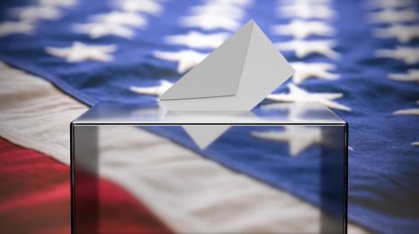 USA election. White envelope in a clear glass transparent ballot box slot against blur USA flag background. 3d illustration